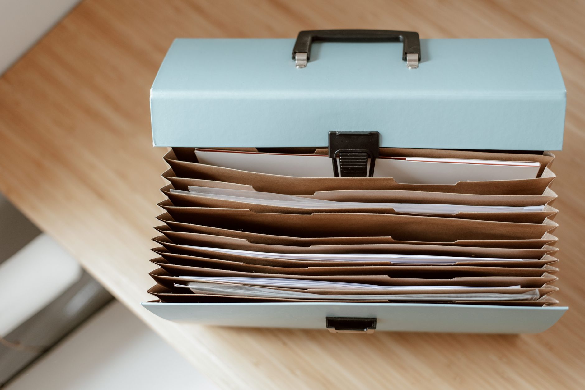 Un classeur de documents techniques et de factures posé sur une table, représentant le carnet d'information du logement