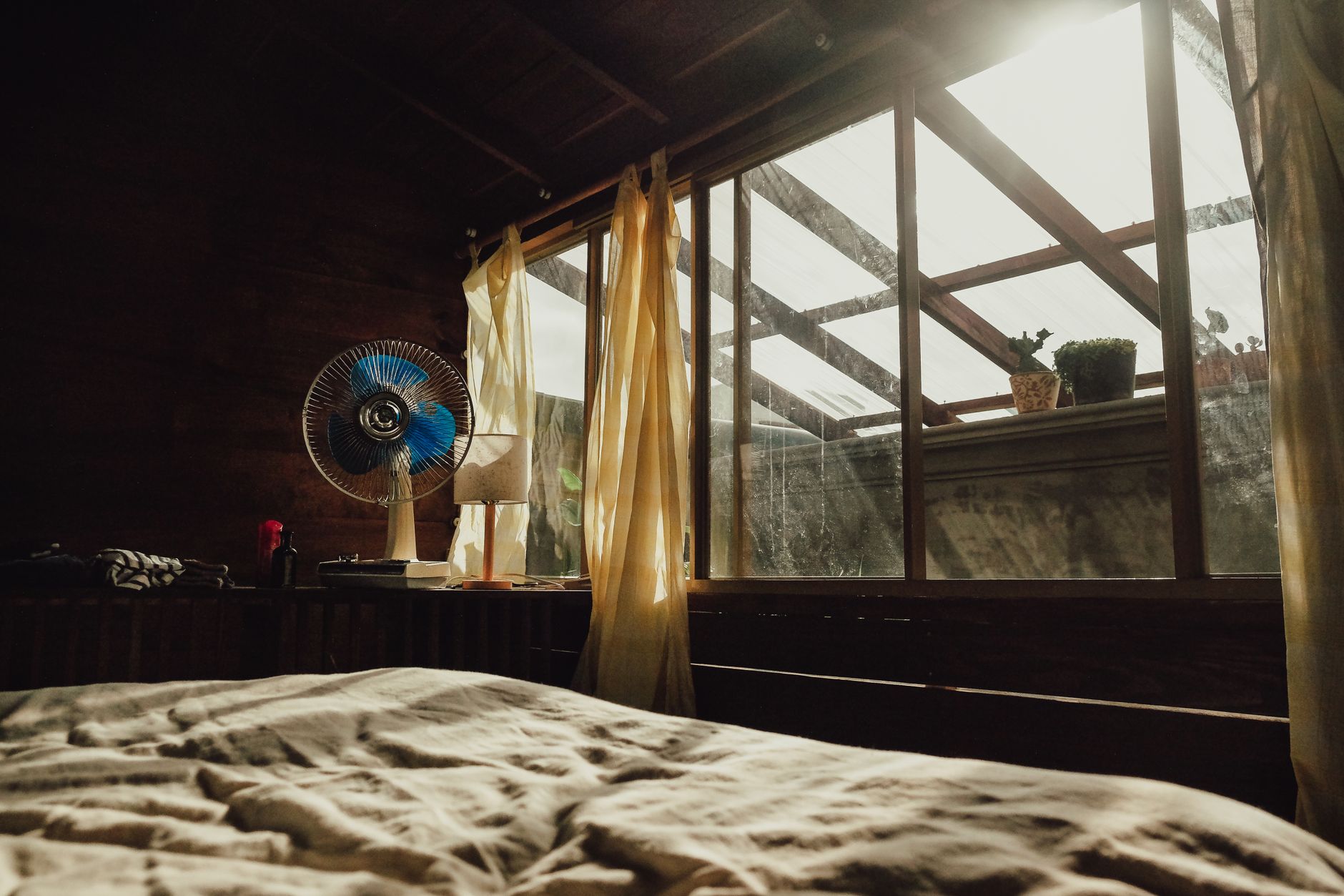 Fenêtre de chambre ouverte la nuit avec un ventilateur, ambiance rafraîchissante