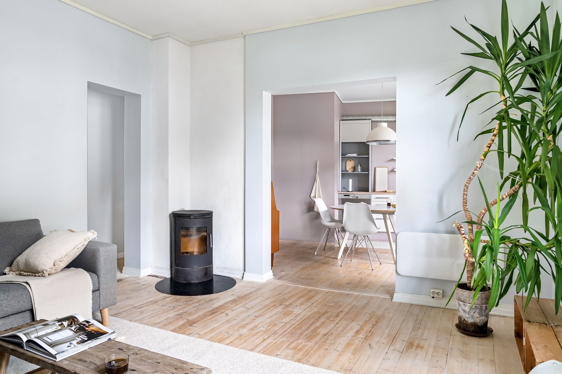 Un poêle à bois moderne allumé dans un salon chaleureux, avec des flammes visibles derrière la vitre.