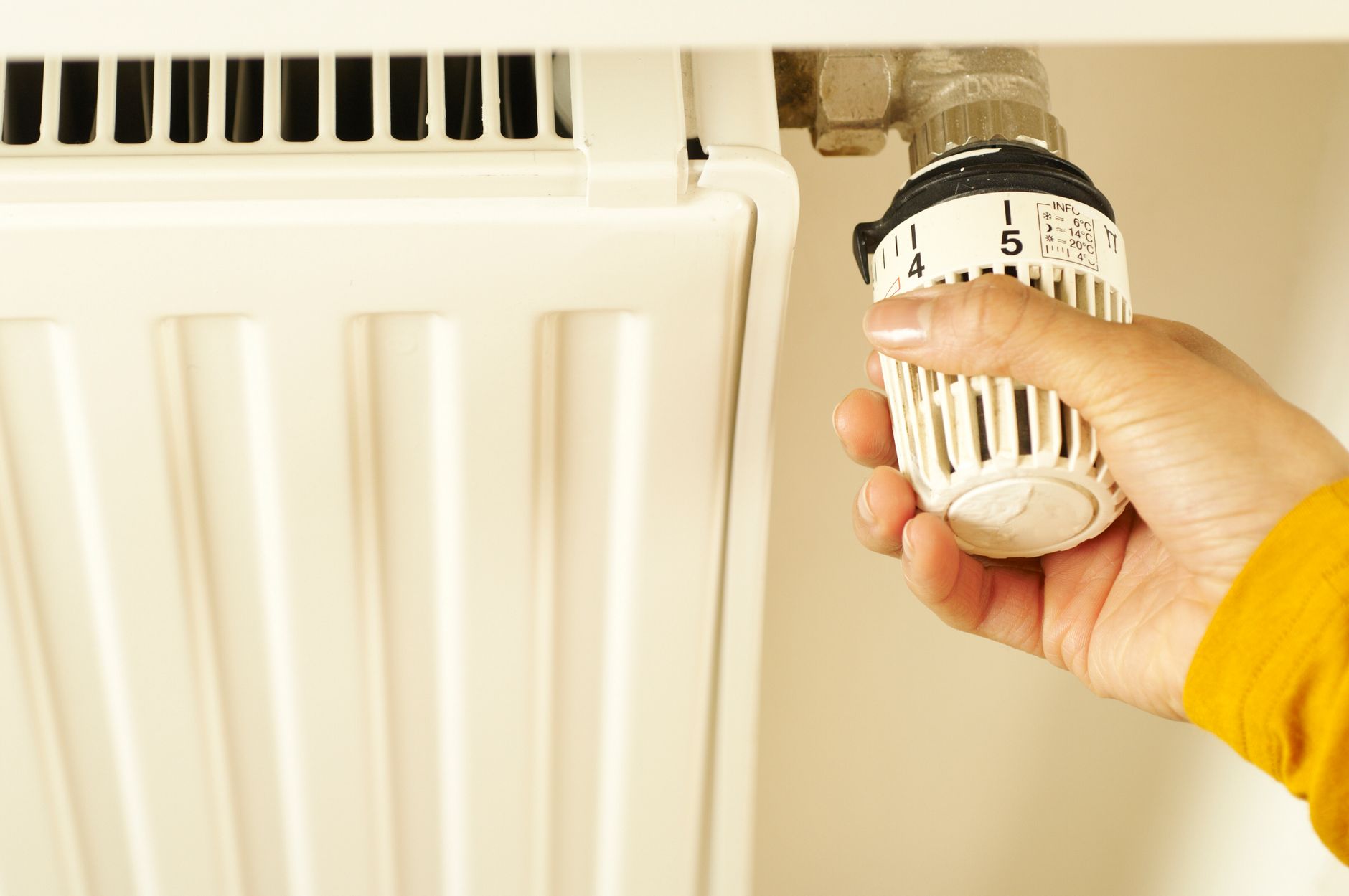 Gros plan sur la vanne d'un radiateur en fonte dans un salon